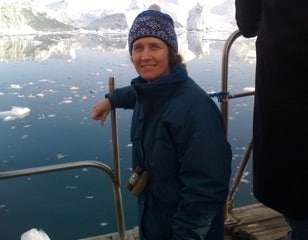 Pam Pearson on a boat in the Arctic, wearing winter gear