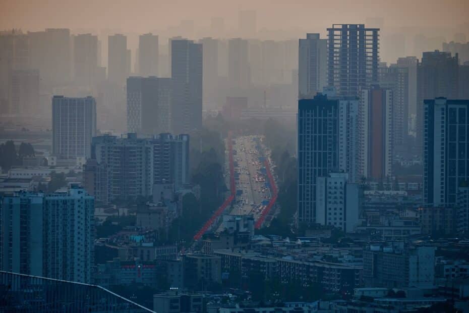 a city skyline of high-rise buildings darkened by smog