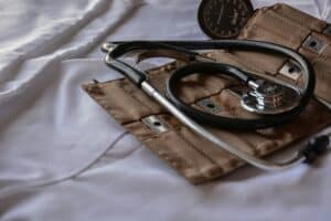 a stethoscope and blood pressure arm band laying on white fabric