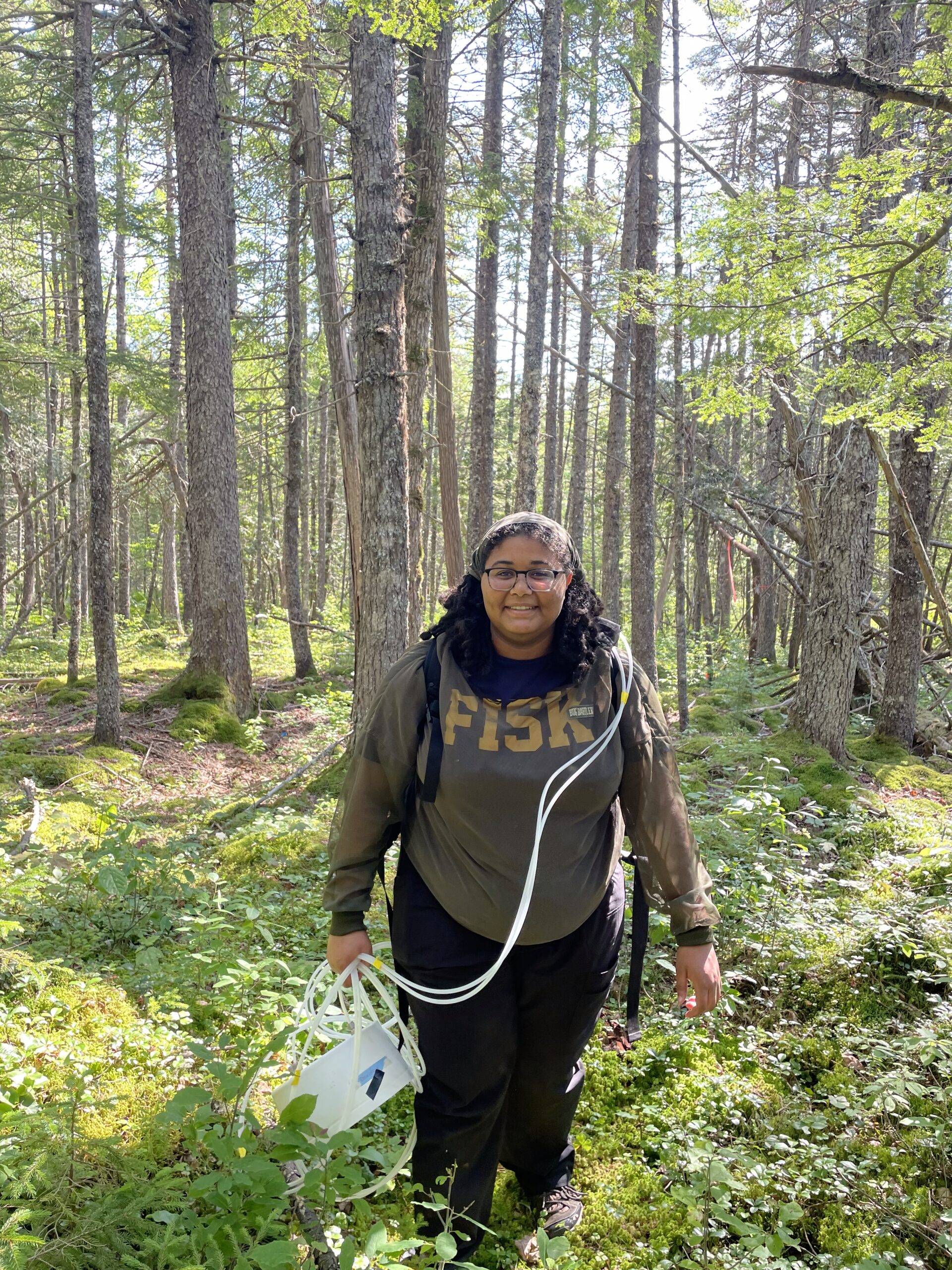 Student researcher sinclair strong caries equipment through forest