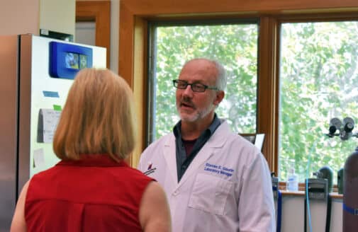 steve gaurin explains a piece of lab machinery, to visitors