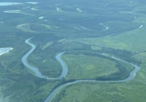 aerial view of a large loop in the yukon river, meandering through lush green tundra