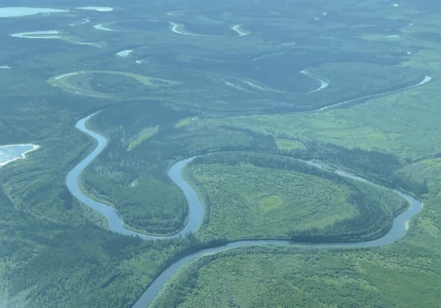 aerial view of a large loop in the yukon river, meandering through lush green tundra