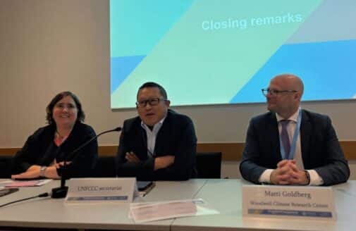 matti goldberg sits in front of a presentation screen with fellow presenters on a panel at bonn 2025