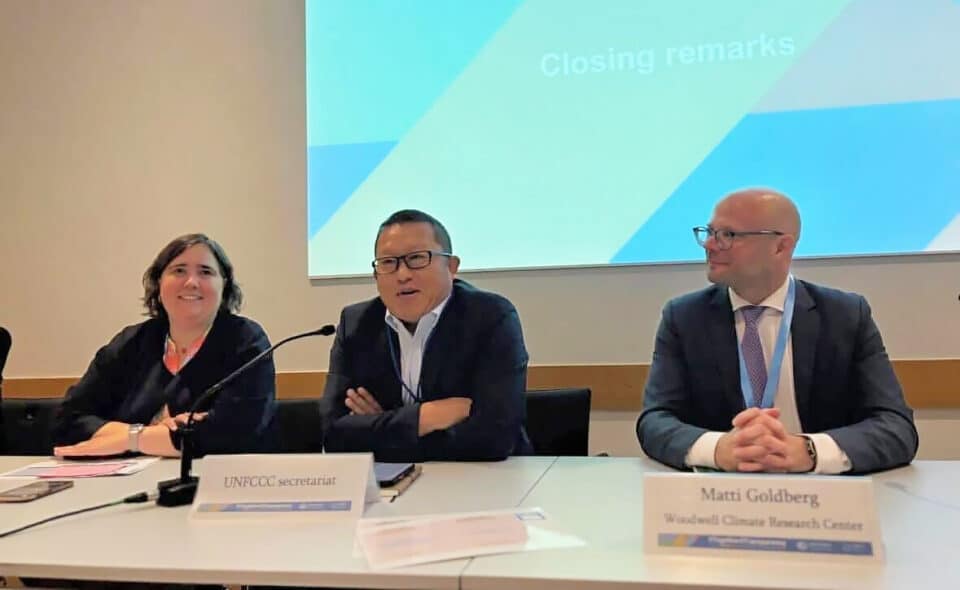 Matti Goldberg sits in front of a presentation screen with fellow presenters on a panel at bonn 2025