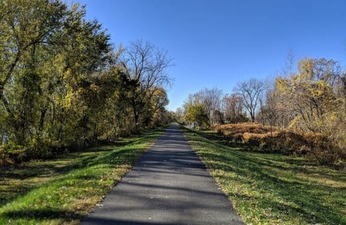 a bike path runs atop a levee into the distance