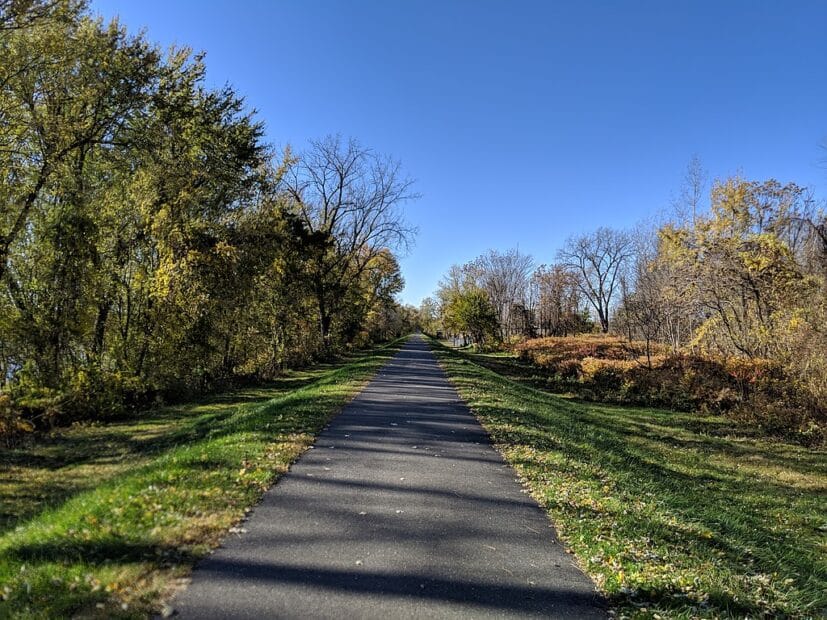 a bike path runs atop a levee into the distance