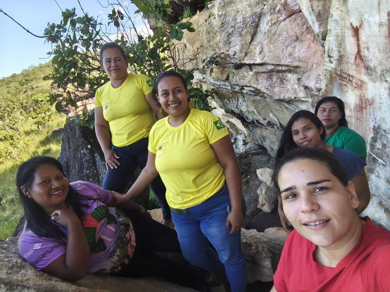 a group of women stand on a mountain trail smiling at the camera