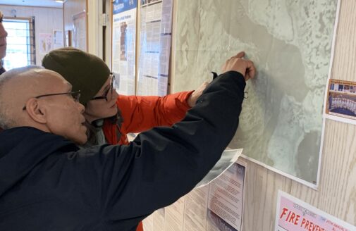 Morris Alexie and Sue Natali examine a map during a community visit to the Alaska Native Village of Nunapicuaq.