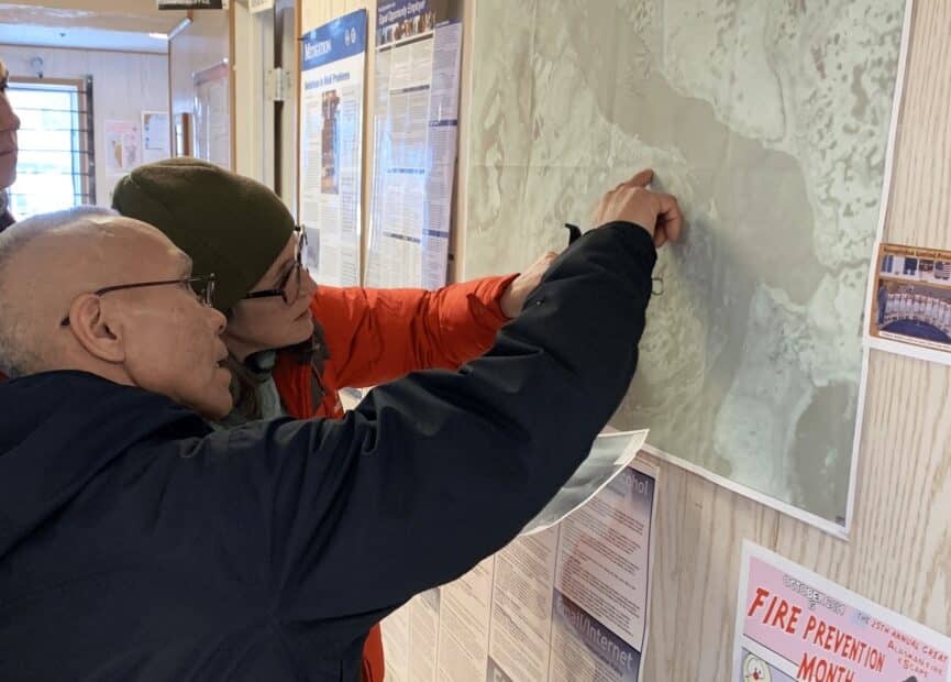 Morris Alexie and Sue Natali examine a map during a community visit to the Alaska Native Village of Nunapicuaq.