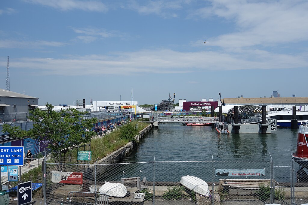 a small basin with boats docked and some vegetation growing on a concrete-reinforced shore