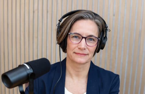 headshot of Heather Goldstone with headphones and a microphone