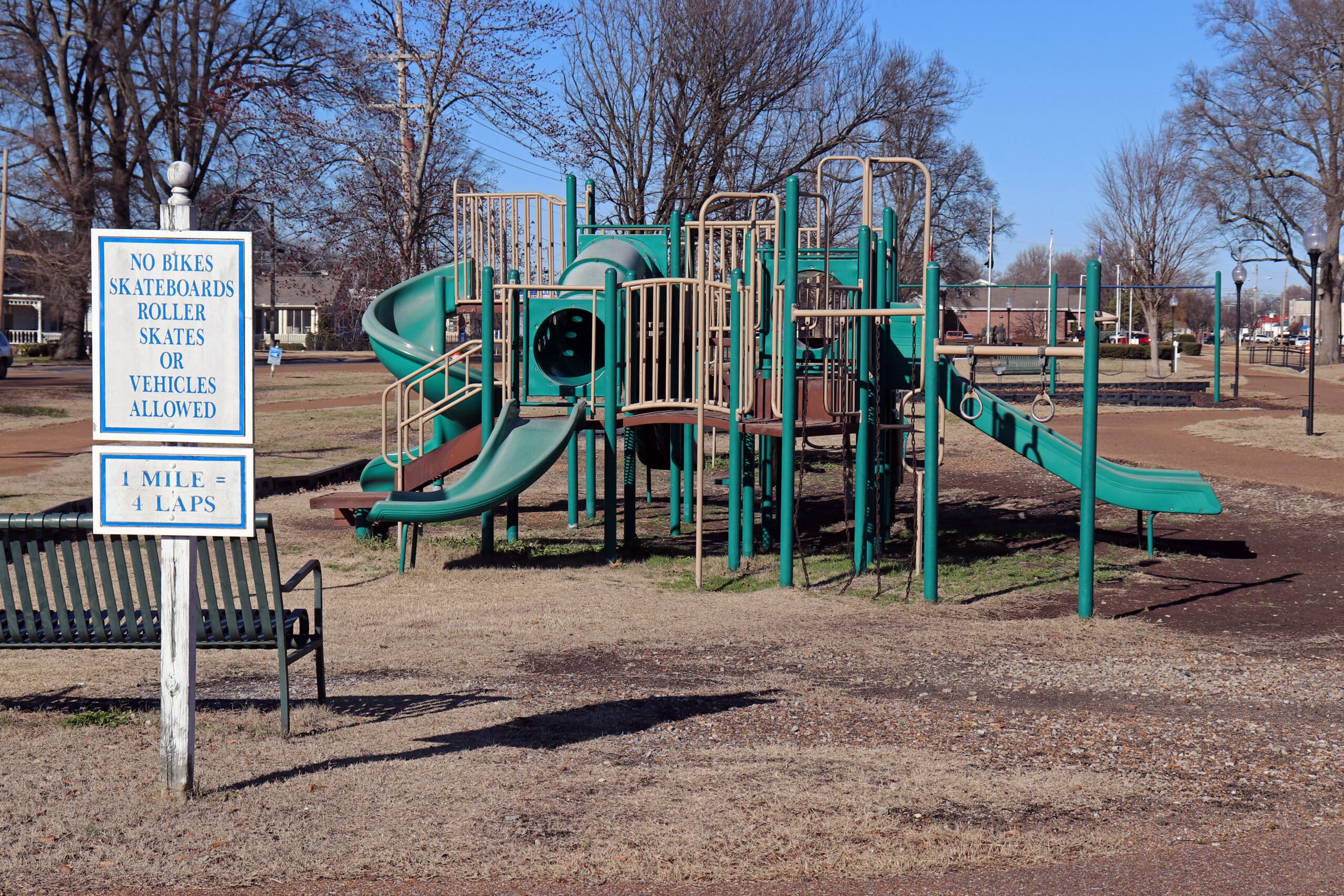 a green and yellow playground set in bright sun