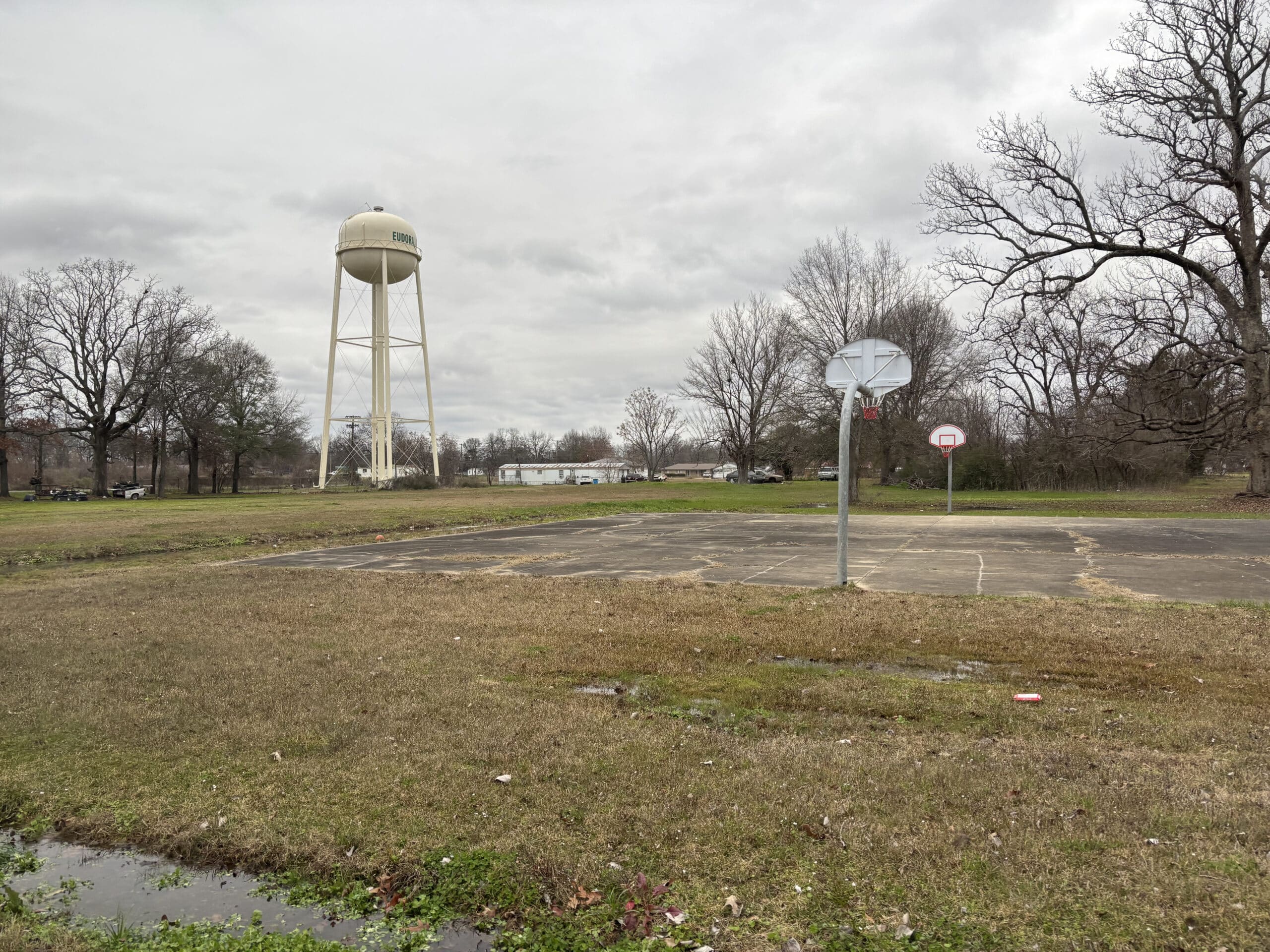 a water tower overlooking a public park with flooded ditches
