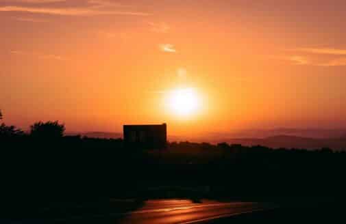 a sunset in an orange sky over a dark skyline