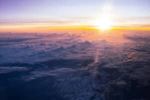 a photo taken above the cloud layer, the sun on the horizon